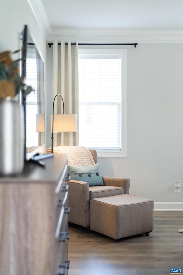 sitting room with ornamental molding, wood finished floors, and baseboards