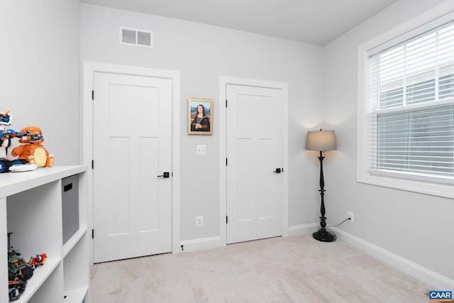 bedroom featuring light carpet and baseboards