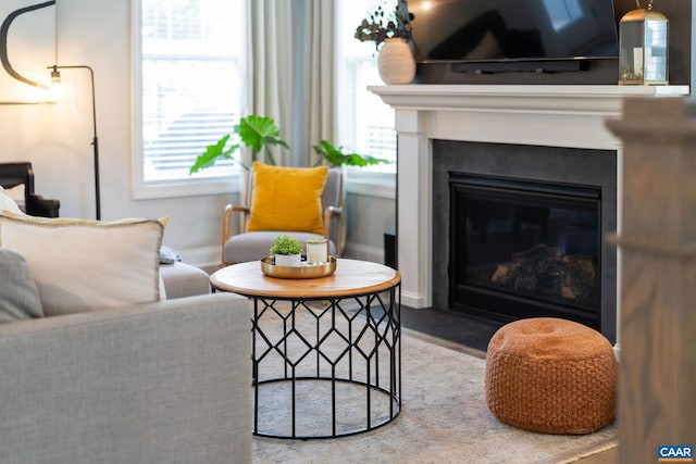 living room featuring a glass covered fireplace and baseboards