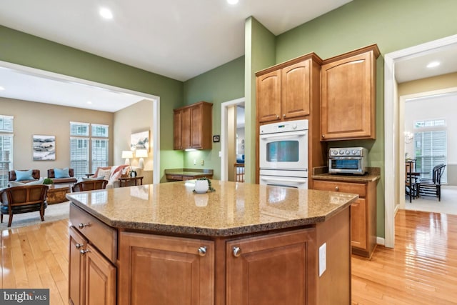 229 Bowen Ct, Annapolis, MD 21401 - kitchen featuring double oven, a center island, light stone counters, light wood-type flooring, and recessed lighting