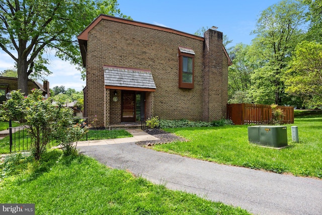 view of front facade with brick siding and a chimney