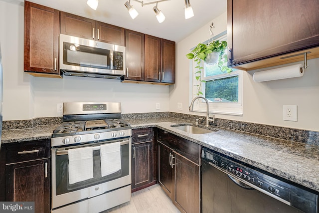 2015 Rollins Dr, Alexandria, VA 22307 - kitchen with stainless steel appliances, a sink, dark brown cabinets, and light wood finished floors