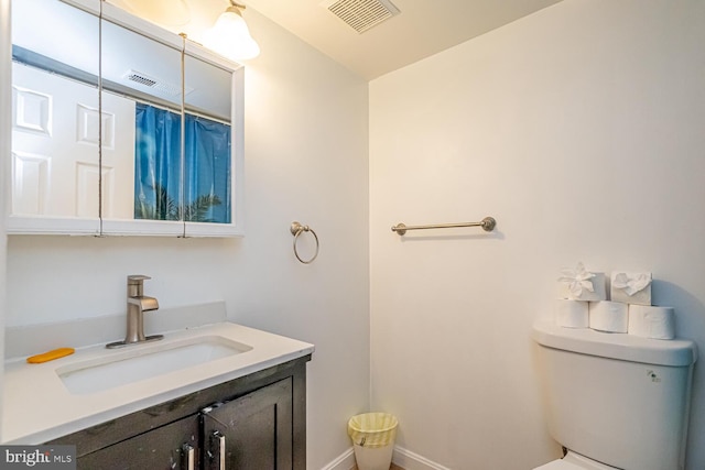 bathroom with vanity, toilet, and baseboards
