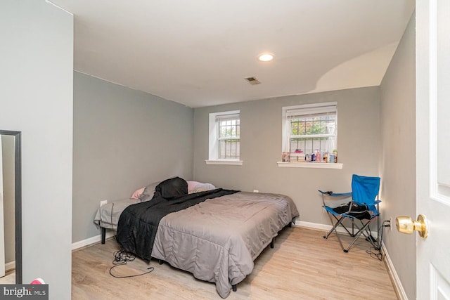 bedroom featuring wood finished floors, baseboards, and recessed lighting