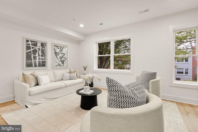 living room with baseboards, light wood-type flooring, and recessed lighting