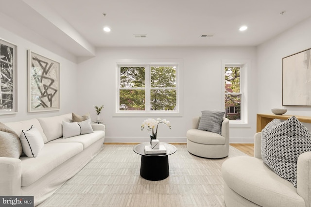 living room featuring light wood-type flooring, baseboards, and recessed lighting