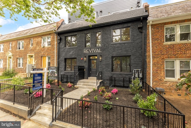 multi unit property featuring brick siding and a shingled roof