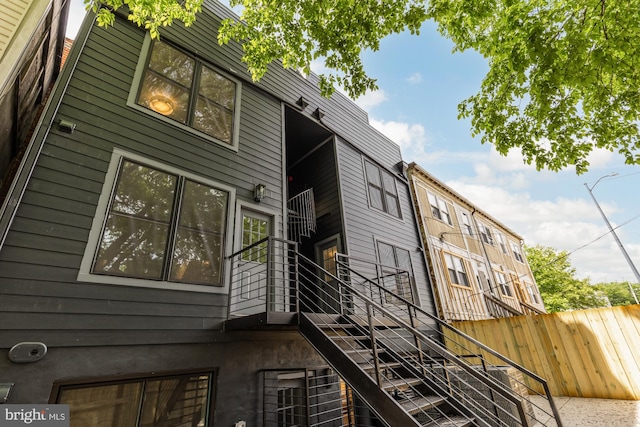 view of property exterior with stairway and fence
