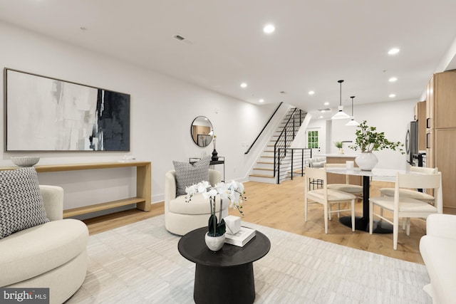 living area with stairs, recessed lighting, and light wood finished floors