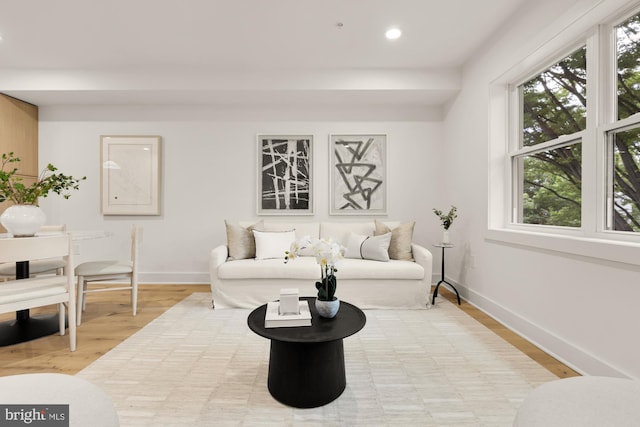 living area featuring healthy amount of natural light, recessed lighting, baseboards, and light wood finished floors