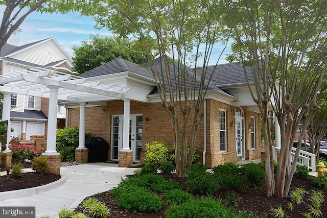 411 Hamlet Club Dr Unit 104, Edgewater, MD 21037 - view of front facade featuring a pergola, brick siding, and roof with shingles