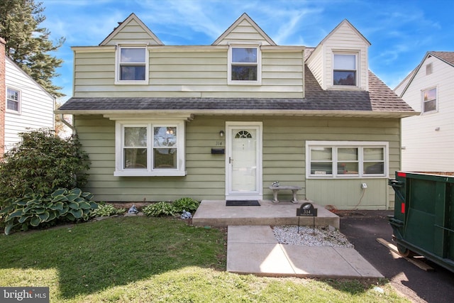 view of front of house featuring roof with shingles and a front yard