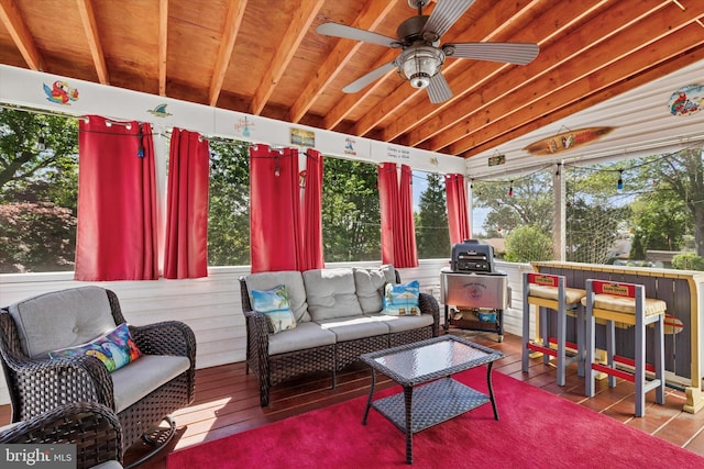 sunroom with plenty of natural light, outdoor lounge area, vaulted ceiling, and a ceiling fan