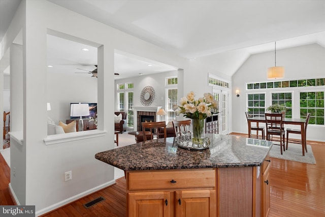 47433 River Crest St, Sterling, VA 20165 - kitchen featuring light wood finished floors, a ceiling fan, a brick fireplace, pendant lighting, and lofted ceiling