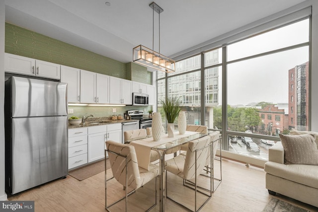 1414 Belmont St NW Unit 207, Washington, DC 20009 - dining room with light wood-style flooring and a wall of windows