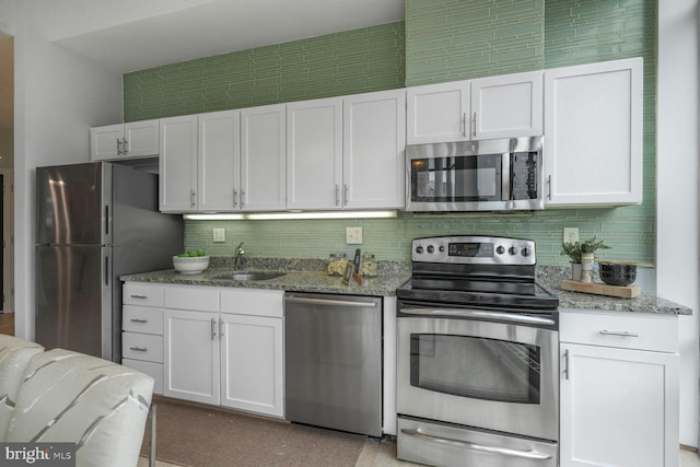 1414 Belmont St NW Unit 207, Washington, DC 20009 - kitchen with appliances with stainless steel finishes, a sink, white cabinetry, light stone countertops, and tasteful backsplash