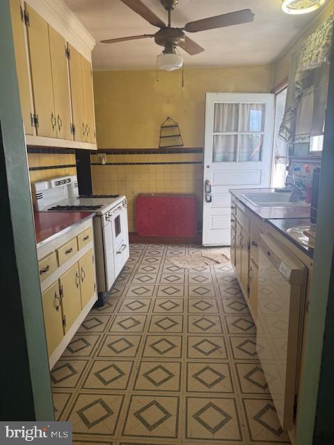 110 N Main St, Union Bridge, MD 21791 - kitchen featuring white range with electric cooktop, a ceiling fan, a sink, dishwashing machine, and tile walls