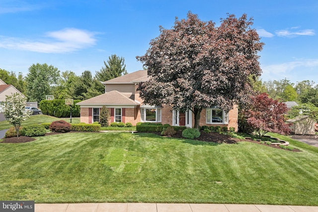 view of front of home with a front lawn and brick siding