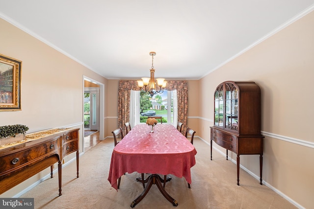 dining room with a chandelier, light carpet, crown molding, and baseboards