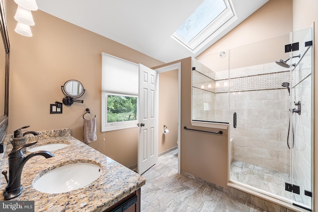 full bathroom featuring a skylight, a stall shower, double vanity, vaulted ceiling, and marble look tile flooring