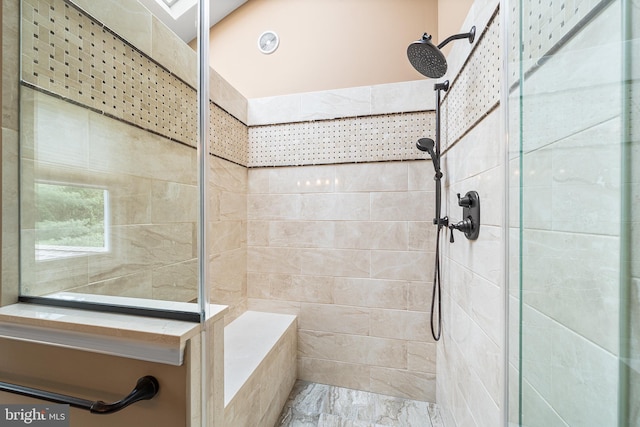 bathroom with tiled shower and marble finish floors