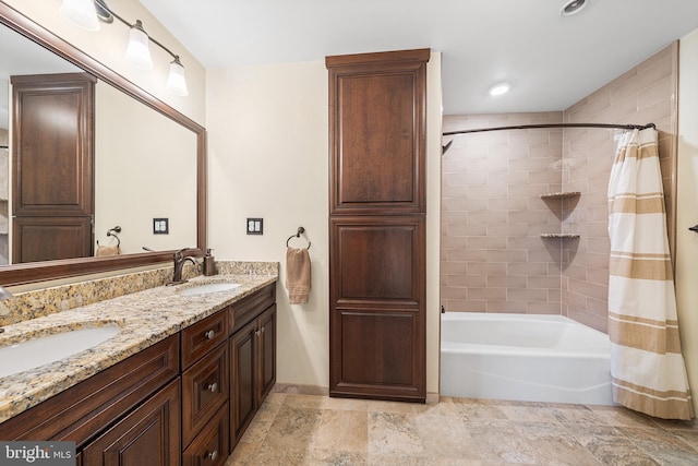 bathroom featuring shower / tub combo, baseboards, double vanity, and stone finish floors