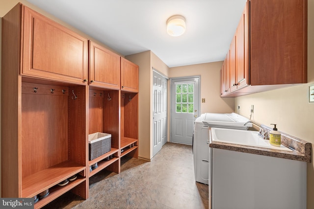 laundry area with independent washer and dryer and cabinet space