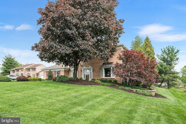 view of front facade featuring a front yard and brick siding