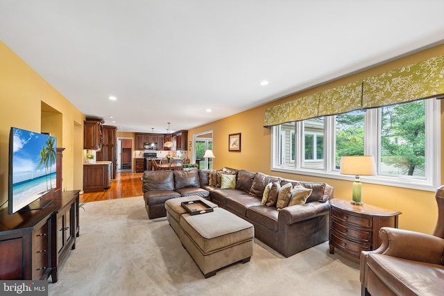 living room featuring recessed lighting, light wood finished floors, and a chandelier