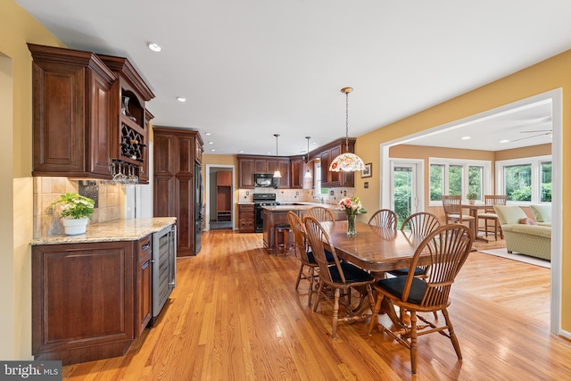 dining room featuring light wood finished floors, beverage cooler, and recessed lighting