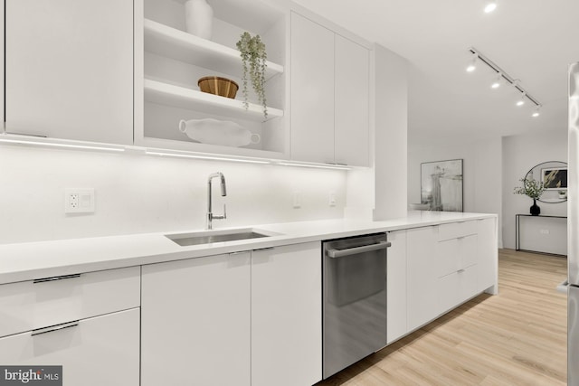 kitchen with dishwasher, a sink, modern cabinets, rail lighting, and white cabinets