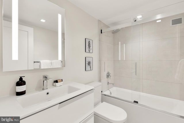 full bath with toilet, enclosed tub / shower combo, and vanity