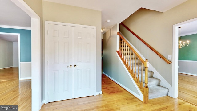 7265 Latham Ct, Hughesville, MD 20637 - stairs with wood finished floors, a chandelier, and baseboards