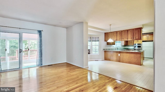 7265 Latham Ct, Hughesville, MD 20637 - kitchen with freestanding refrigerator, light wood finished floors, open floor plan, brown cabinets, and a sink