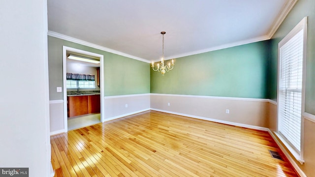 7265 Latham Ct, Hughesville, MD 20637 - spare room with wood-type flooring, a chandelier, a sink, ornamental molding, and baseboards