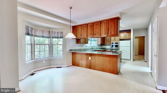7265 Latham Ct, Hughesville, MD 20637 - kitchen featuring freestanding refrigerator, brown cabinets, a sink, a peninsula, and baseboards