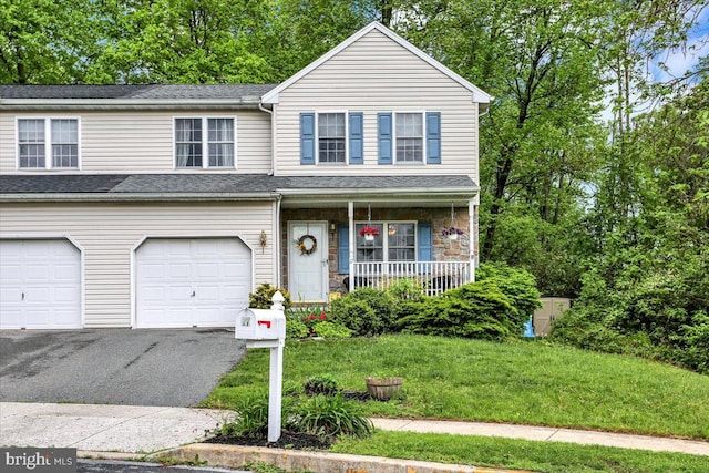 view of front of home featuring a porch, asphalt driveway, an attached garage, a front lawn, and stone siding