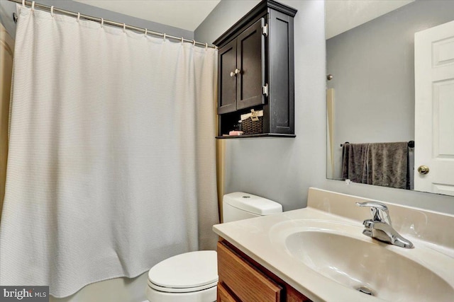 full bath with toilet, vanity, and shower / tub combo with curtain