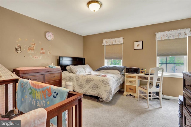 bedroom featuring multiple windows, light colored carpet, and baseboards
