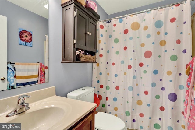 full bathroom with toilet, vanity, and curtained shower
