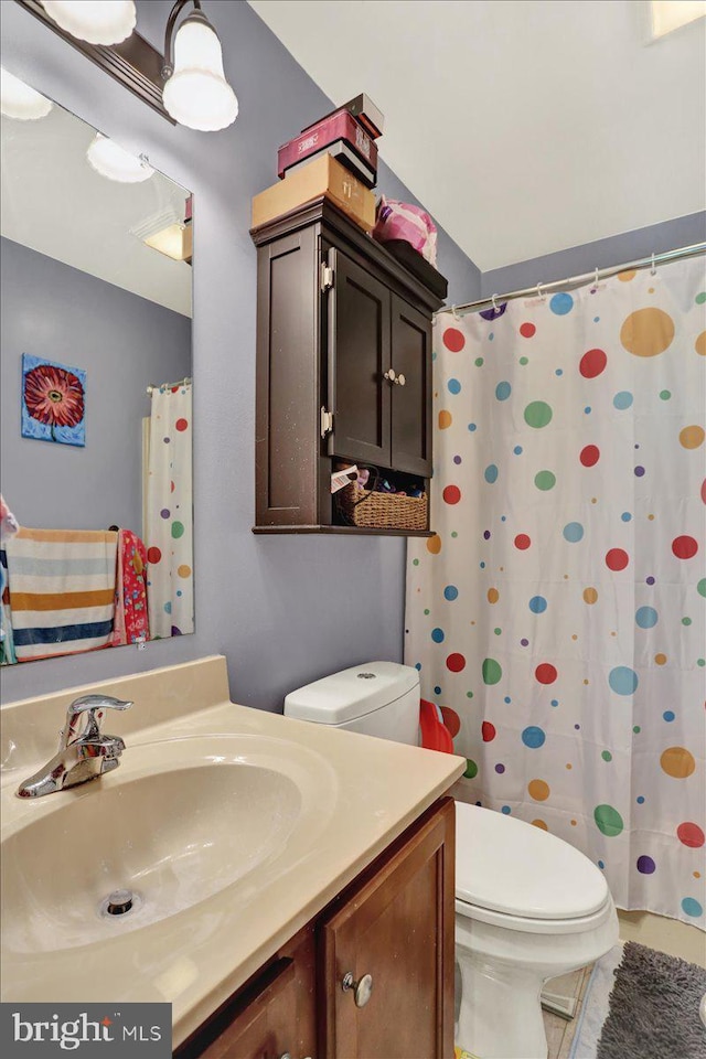 full bathroom featuring toilet, vanity, tile patterned floors, and a shower with curtain