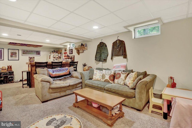 living room featuring a drop ceiling, carpet, and recessed lighting
