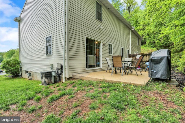 back of property featuring a patio, central air condition unit, and a lawn