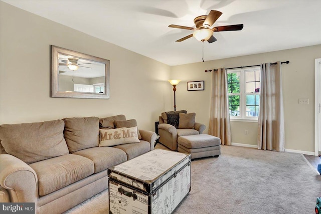 living area featuring ceiling fan, light colored carpet, and baseboards