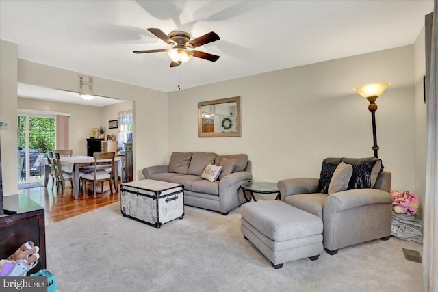 living area featuring ceiling fan and light carpet