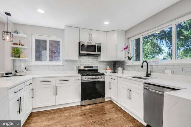 7603 Hammond Ave, Takoma Park, MD 20912 - kitchen featuring stainless steel appliances, open shelves, a sink, light stone counters, and white cabinetry