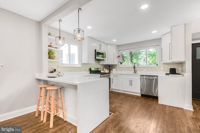 7603 Hammond Ave, Takoma Park, MD 20912 - kitchen featuring stainless steel appliances, a sink, a peninsula, decorative backsplash, and recessed lighting