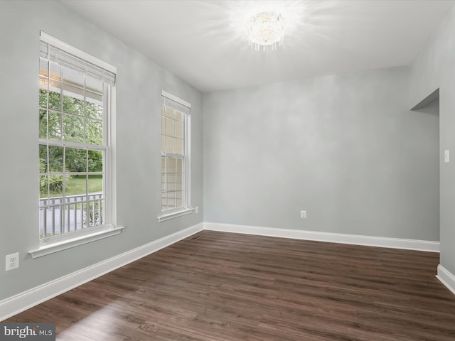 8484 Oak Run Way, Ellicott City, MD 21043 - unfurnished room with a chandelier, dark wood-type flooring, and baseboards