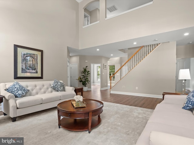 8484 Oak Run Way, Ellicott City, MD 21043 - living area featuring wood finished floors, stairway, baseboards, recessed lighting, and a towering ceiling
