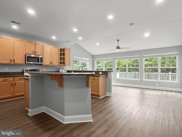 8484 Oak Run Way, Ellicott City, MD 21043 - kitchen featuring stainless steel microwave, a center island, dark wood finished floors, a kitchen breakfast bar, and glass insert cabinets